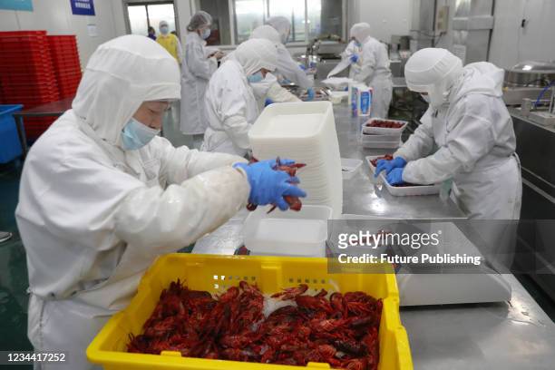 People work on the ready-to-eat crayfish at a processor in Nantong city in east China&#039;s Jiangsu province Saturday, July 31, 2021.