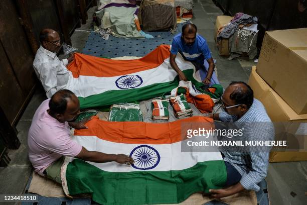 Workers inspect Indian national flags ahead of the country's 75th Independence Day celebrations at a workshop in Mumbai on August 3, 2021.