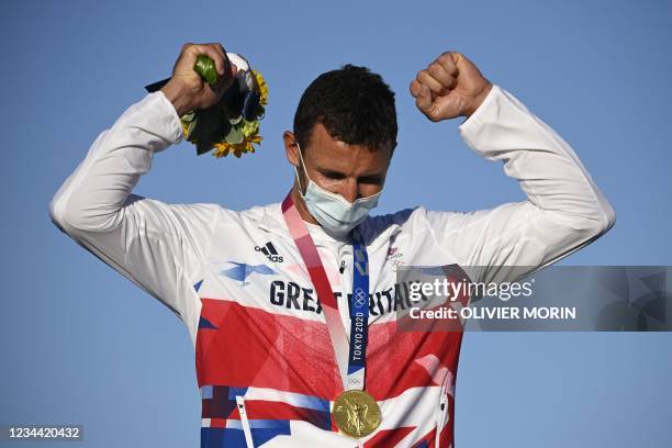 Great Britain's Giles Scott celebrates on the podium in the men's one-person dinghy finn race during the Tokyo 2020 Olympic Games sailing competition...