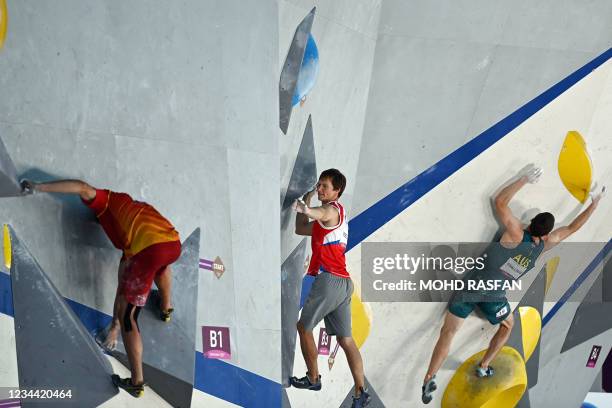 Spain's Alberto Gines Lopez Russia's Aleksey Rubtsov and Australia's Tom O'halloran compete in the men's sport climbing bouldering qualification...