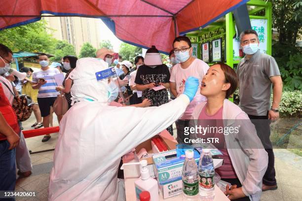 Resident is given a nucleic acid test for the coronavirus in Wuhan in China's central Hubei province on August 3 as the city tests its entire...