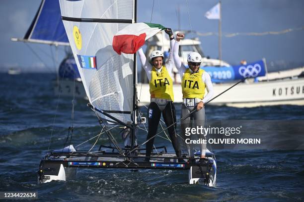 Italy's Ruggero Tita and Caterina Banti celebrate winning the gold medal after the mixed multihull Nacra 17 foiling race during the Tokyo 2020...