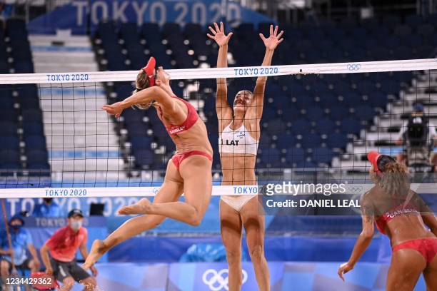 Canada's Heather Bansley attempts a shot past Latvia's Tina Graudina in their women's beach volleyball quarter-final match between Latvia and Canada...
