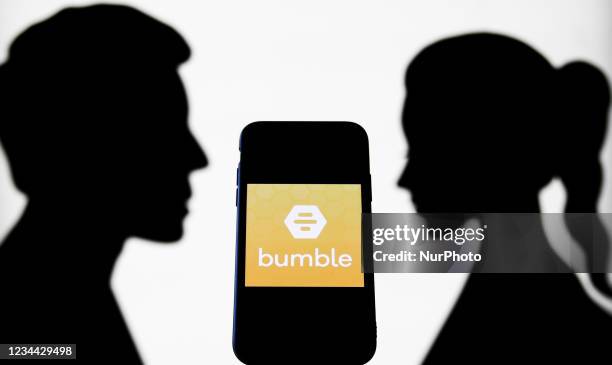 Bumble logo displayed on a phone screen is seen with paper silhouettes looking like a man and a woman in this illustration photo taken in Krakow,...