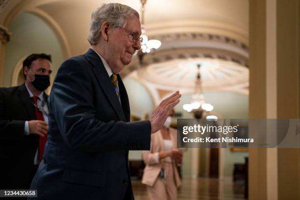 Senate Minority Leader Mitch McConnell waves at Sen. Debbie Stabenow while walking out from the Senate Chamber towards his office on Capitol Hill on...