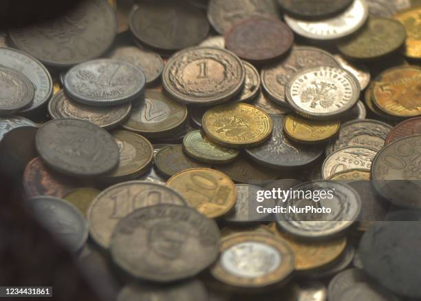 Polish ZLoty coins and coins from all over the world left by visitors in the box on the Main Square in Krakow. On Tuesday, August 3 in Krakow, Lesser...