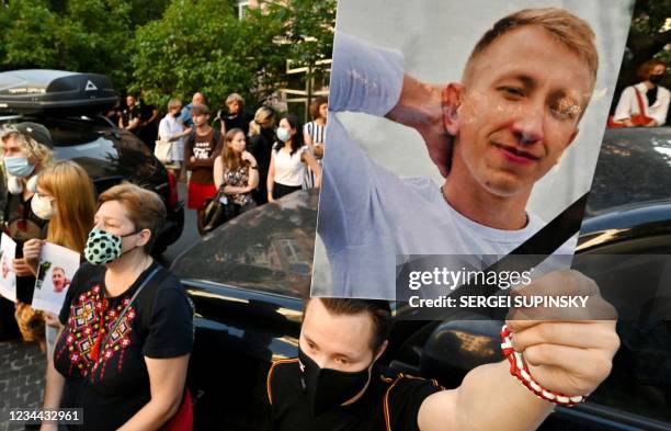 Picture of Vitaly Shishov is held by an activist as he takes part in a rally outside the Belarus embassy in Kiev on August 3 in memory of Vitaly...