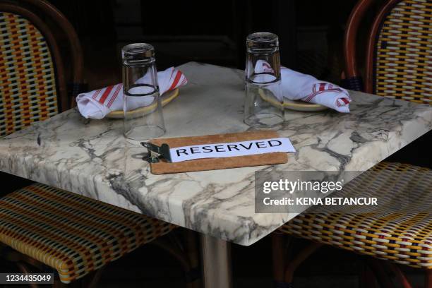 Empty tables stand at a restaurant in midtown on August 03, 2021 in New York. - Mayor Bill de Blasio has just announced "first in the nation" vaccine...