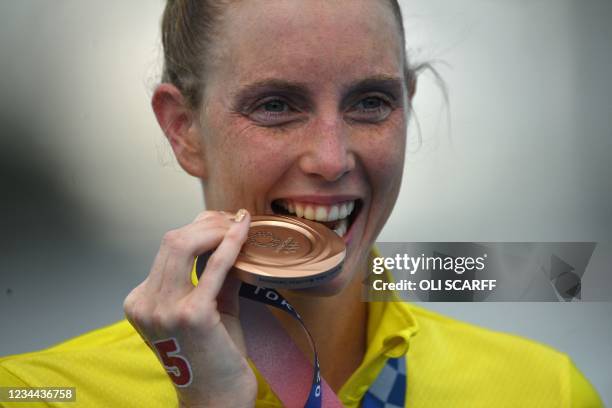 Australia's Kareena Lee bites her bronze medal at a ceremony after the women's 10km marathon swimming event during the Tokyo 2020 Olympic Games at...