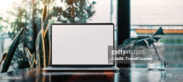 laptop computer blank screen on table in cafe background. laptop with blank screen on table of coffee shop blur background. - schreibtisch stock-fotos und bilder