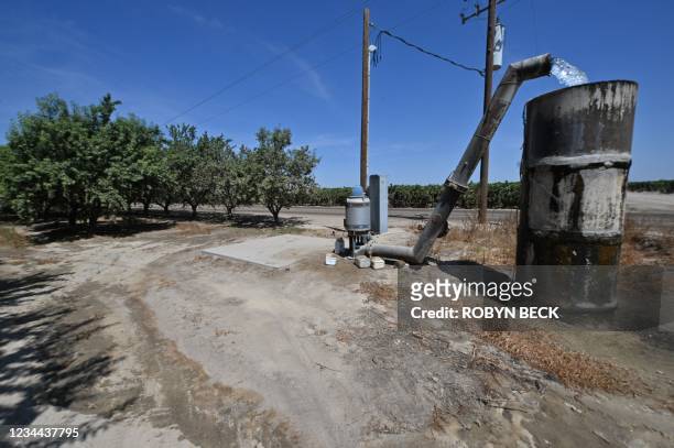 Water pumped up from an underground well flows into a cistern on a farm in Fresno, California, July 24, 2021. - Central Valley farmers, desperate for...