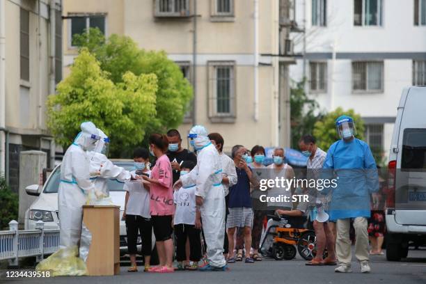 This photo taken on August 3, 2021 shows residents queueing to test for the Covid-19 coronavirus in Yangzhou in China's eastern Jiangsu province. -...