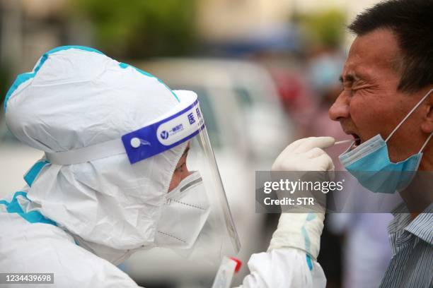 This photo taken on August 3, 2021 shows a resident receiving nucleic acid tests for the Covid-19 coronavirus in Yangzhou in China's eastern Jiangsu...