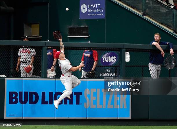 Tyler O'Neill of the St. Louis Cardinals leaps at the wall to catch a ball hit by Adam Duvall of the Atlanta Braves during the eighth inning at Busch...