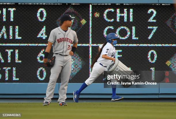 Michael Brantley of the Houston Astros watches as a bat girl removes an inflatable trash can that was thrown on to the field in the first inning...