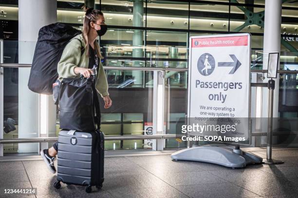 Passenger wearing a face mask as a preventive measure against the spread of coronavirus arrive at Heathrow Airport Terminal 2 in London. From...