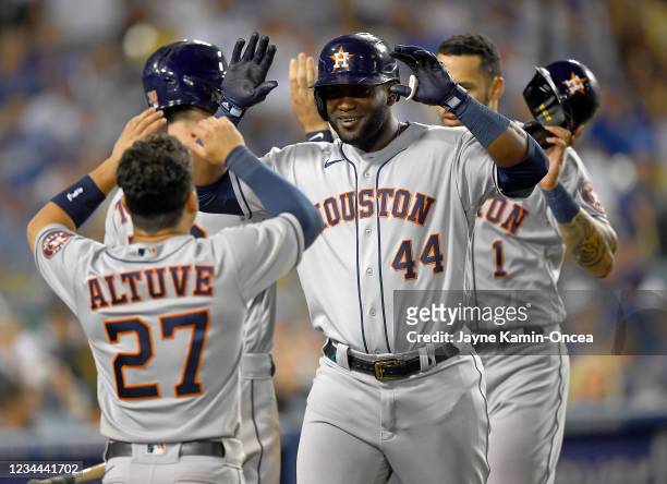 Yordan Alvarez is greeted by Jose Altuve of the Houston Astros after hitting a two-run home run in the eighth inning against the Los Angeles Dodgers...