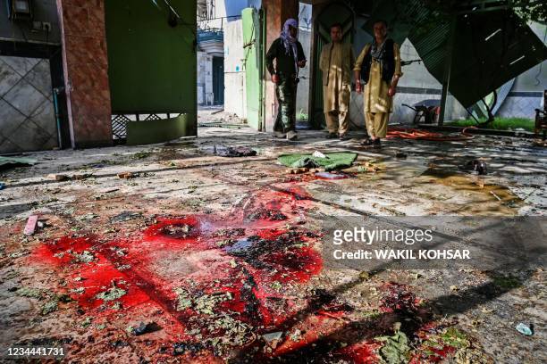 Graphic content / Afghan security personnel stand guard inside a building a day after a car bomb explosion in Kabul on August 4, 2021. / The...