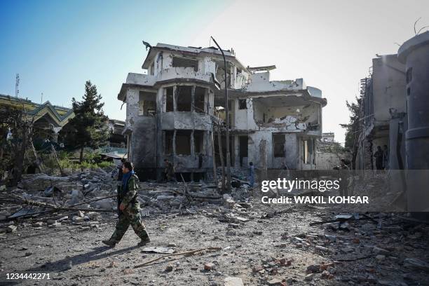 Graphic content / TOPSHOT - An Afghan security personnel inspects the site a day after a car bomb explosion in Kabul on August 4, 2021. / The...