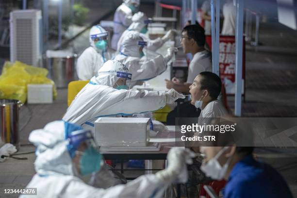 This photo taken on August 3, 2021 shows residents receiving nucleic acid tests for the coronavirus in Wuhan in China's central Hubei province. -...