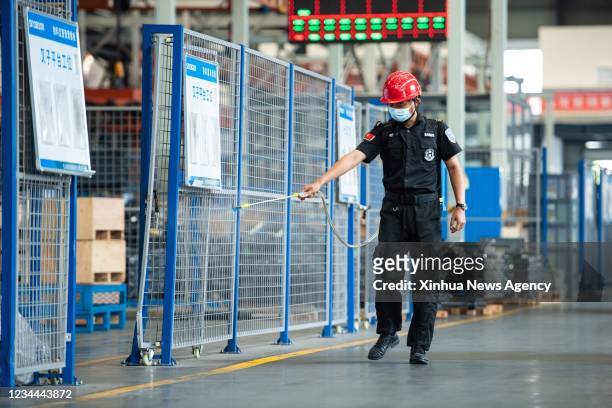 Staff member disinfects a workshop of a company in Ningxiang, Changsha, central China's Hunan Province, Aug. 3, 2021. Many factories in Ningxiang...