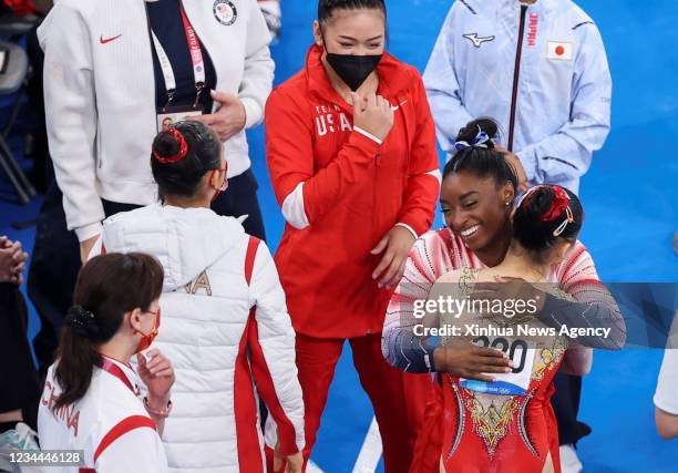 Simone Biles bottom, 2nd R of the United States hugs Guan Chenchen bottom, 1st R of China after the artistic gymnastics women's balance beam final at...