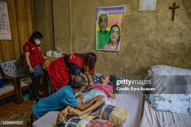 Health worker checks the blood pressure of Virginia Lim, who is suffering from Parkinson's disease, before inoculating her with a dose of the Johnson...