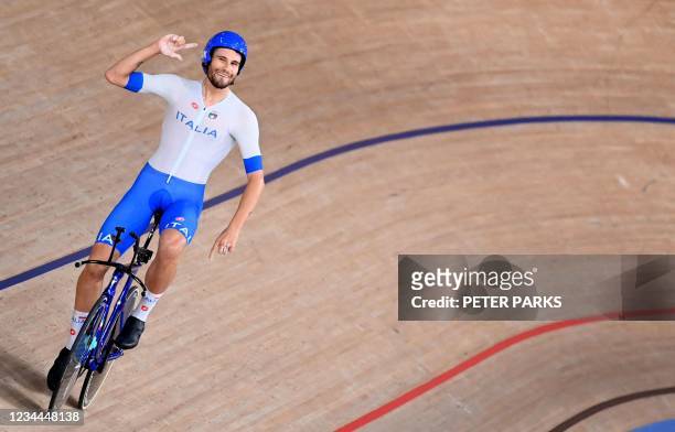 Italy's Filippo Ganna celebrates after winning gold and setting a new World Record in the men's track cycling team pursuit finals during the Tokyo...
