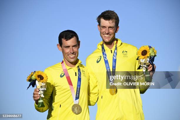 Gold medallists Australia's Mathew Belcher and Will Ryan celebrate on the podium after the men's two-person dinghy 470 medal race during the Tokyo...