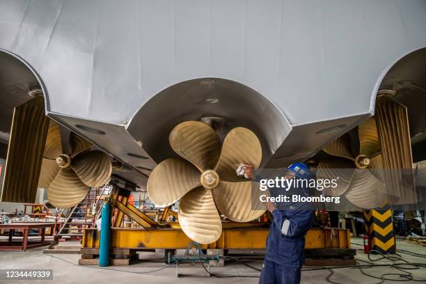 Worker polishes the rear propellers of a 35-metre patrol boat in the Paramount Maritime Holdings shipyard in Cape Town, South Africa, on Thursday,...