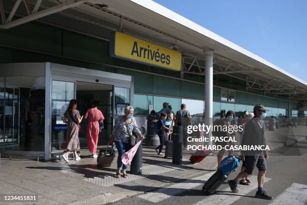 People exit the Napoleon Bonaparte airport in Ajaccio on August 3 as health officials activated an emergency plan on the Mediterranean island of...