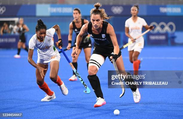 Argentina's Sofia Toccalino dribbles the ball as she is challenged by India's Salima Tete during the women's semi-final match of the Tokyo 2020...