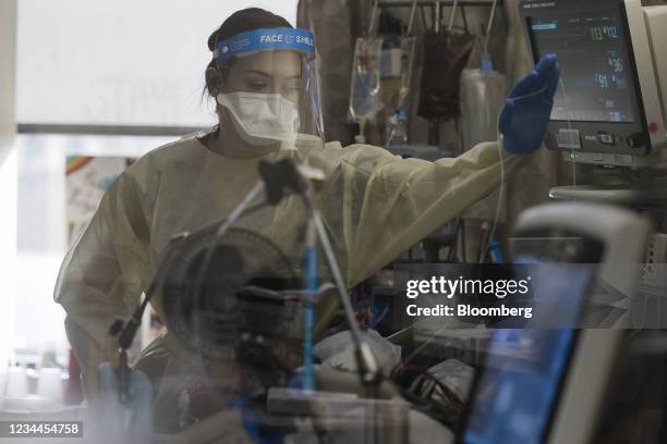 Healthcare worker treats a patient inside a negative pressure room in the Covid-19 intensive care unit at Freeman Hospital West in Joplin, Missouri,...
