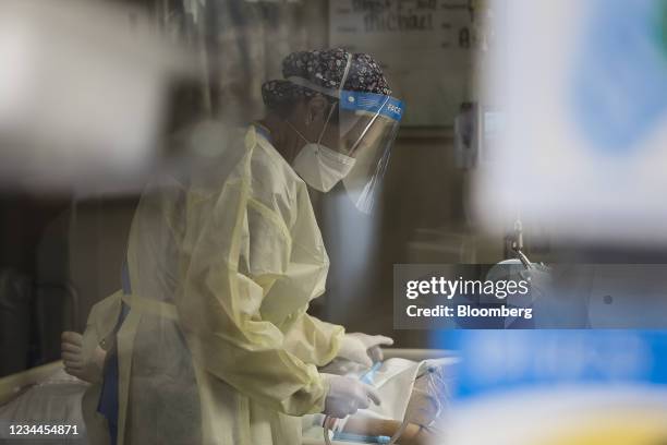 Healthcare worker treats a patient inside a negative pressure room in the Covid-19 intensive care unit at Freeman Hospital West in Joplin, Missouri,...