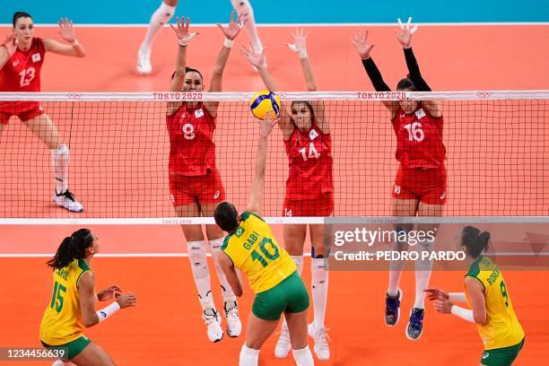 Brazil's Gabriela Braga Guimaraes hits the ball in front of Russia's Nataliya Goncharova, Irina Fetisova and Irina Voronkova in the women's...