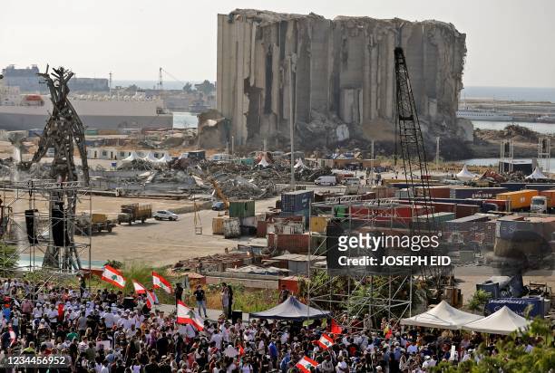 Demonstrators gather near the damaged grain silos outside the port of Lebanon's capital Beirut on August 4 on the first anniversary of the blast that...