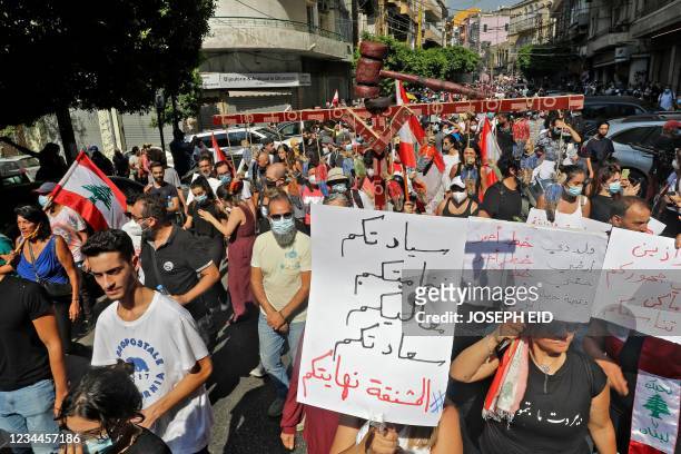 Demonstrator marches with a miniature gallows and a sign reading in Arabic underneath "your excellency, your highness, your honour, your sereneness,...