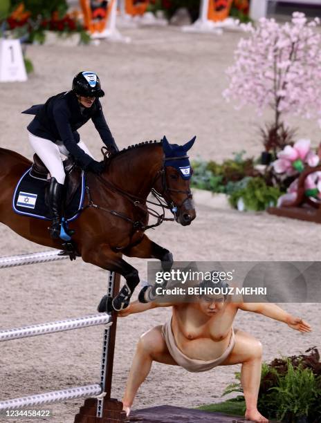 Israel's Ashlee Bond riding Donatello 141 jumps past a sumo statue in the equestrian's jumping individual finals during the Tokyo 2020 Olympic Games...