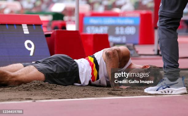 Thomas van der Plaetsen of Belgium lies injured in the sand pit after injuring himself in the men's decathlon long jump during the Athletics event on...