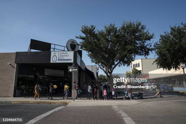 Asylum seekers are lead towards a bus station in McAllen, Texas, U.S., on Wednesday, Aug. 4, 2021. A federal judge temporarily blocked Texas state...