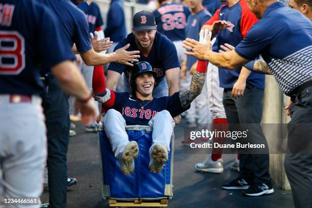 Jarren Duran of the Boston Red Sox is pushed down the dugout by Kevin Plawecki after hitting a solo home run against the Detroit Tigers during the...