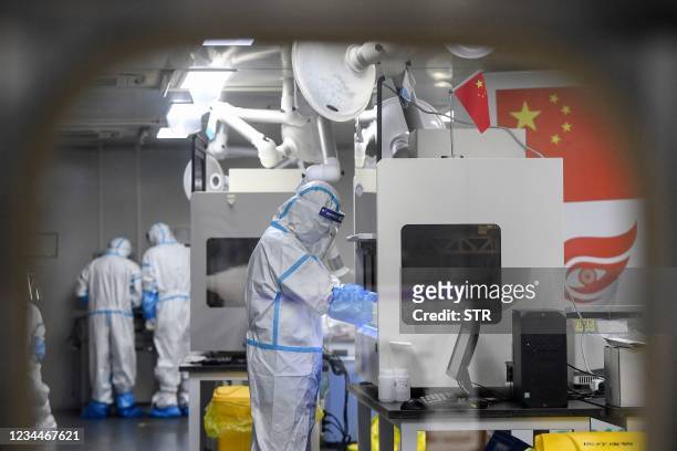 Laboratory technicians wearing personal protective equipment work on samples to be tested for the Covid-19 coronavirus at the Fire Eye laboratory, a...