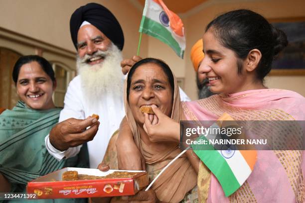 Father Baldev Singh , mother Sukhjinder Singh and sister Gurpreet Kaur of India's field hockey player Gurjant Singh celebrate as India's men's hockey...