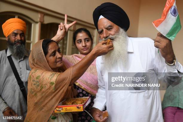 Father Baldev Singh , mother Sukhjinder Singh and sister Gurpreet Kaur of India's field hockey player Gurjant Singh celebrate as India's men's hockey...