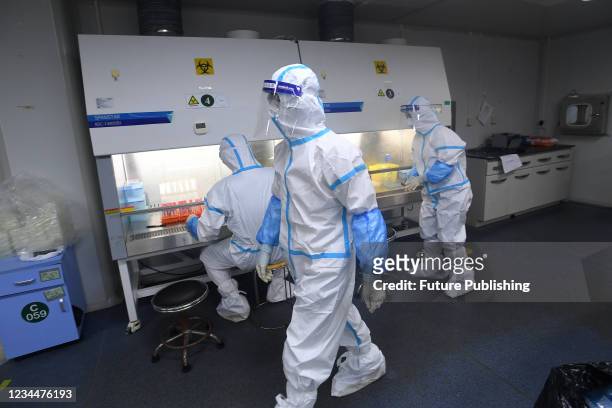 People in PPE work in the Huo-Yan Laboratory designed for high-capacity 2019-nCoV detection in Wuhan in central China&#039;s Hubei province...