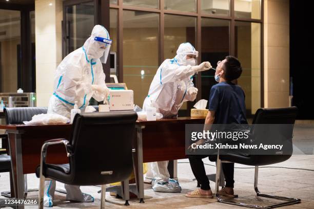Medical worker takes a swab sample from a resident for COVID-19 nucleic acid testing in Zhangjiajie, central China's Hunan Province, Aug. 4, 2021....