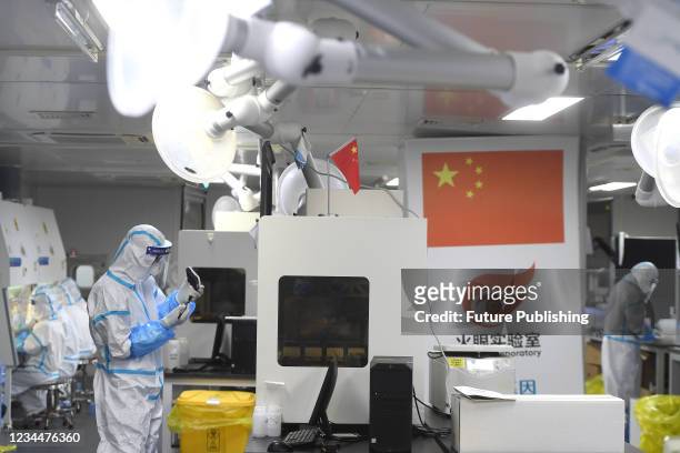People in PPE work in the Huo-Yan Laboratory designed for high-capacity 2019-nCoV detection in Wuhan in central China&#039;s Hubei province...