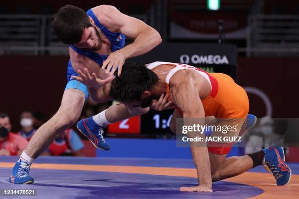 Russia's Zavur Uguev wrestles India's Kumar Ravi in their men's freestyle 57kg wrestling final match during the Tokyo 2020 Olympic Games at the...