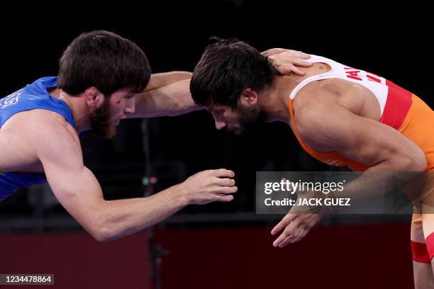 Russia's Zavur Uguev wrestles India's Kumar Ravi in their men's freestyle 57kg wrestling final match during the Tokyo 2020 Olympic Games at the...