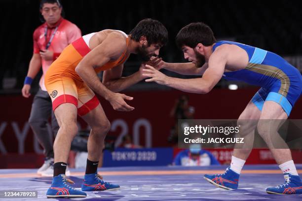 Russia's Zavur Uguev wrestles India's Kumar Ravi in their men's freestyle 57kg wrestling final match during the Tokyo 2020 Olympic Games at the...
